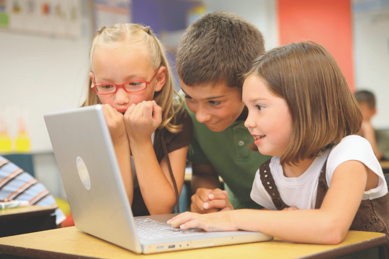 Three children around a computer typing